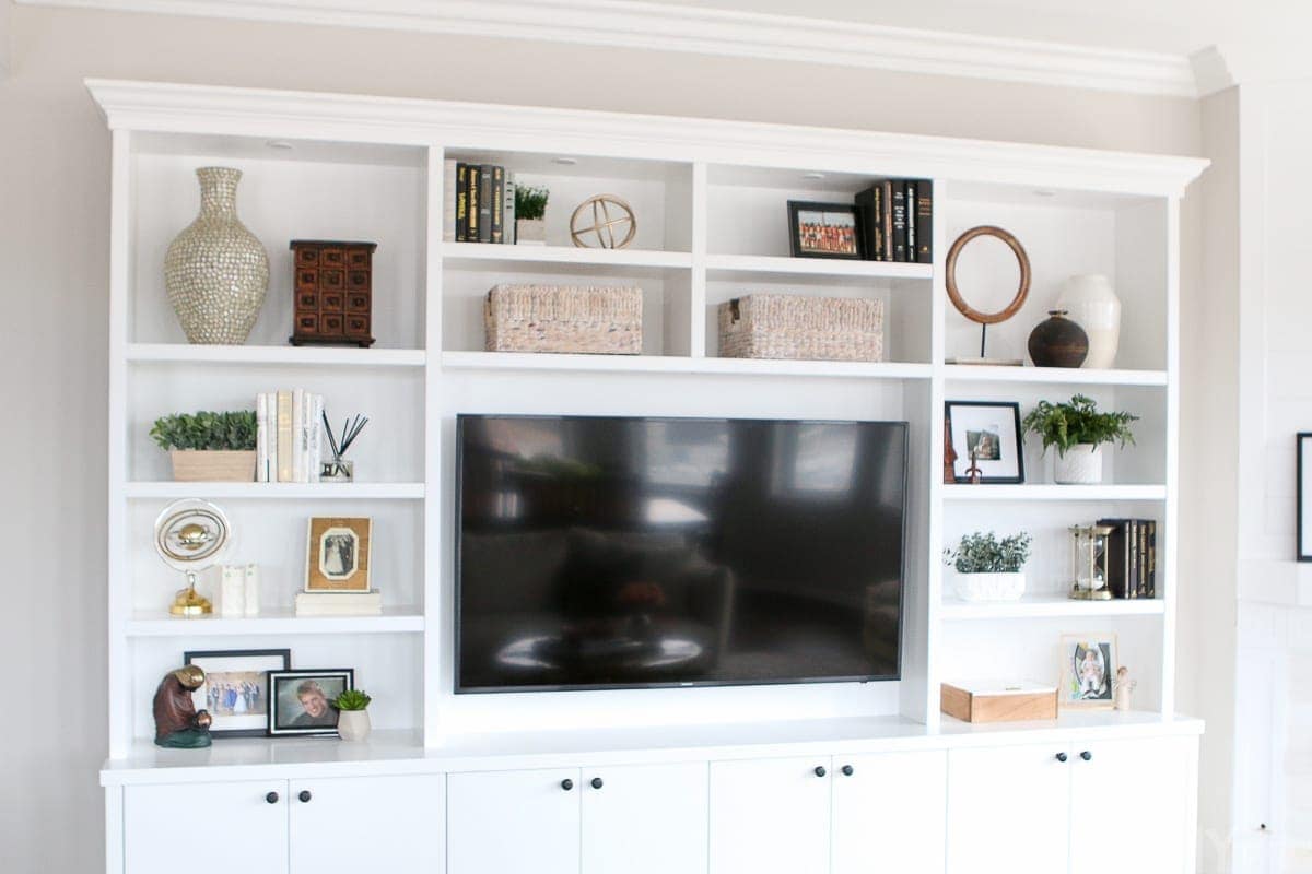 A styled white built-in entertainment center in a family room space. 