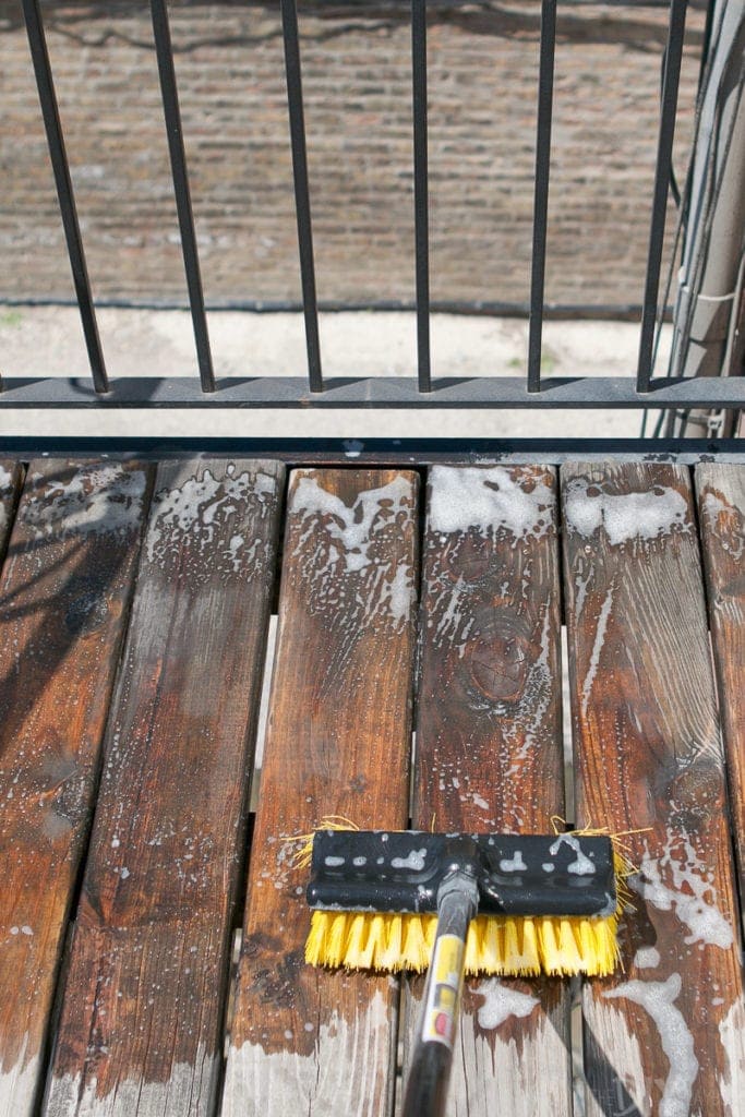 Use a push broom to scrub your deck and get it clean before staining