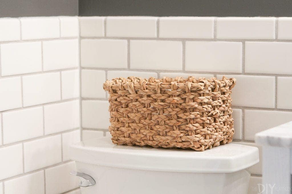 Add a basket behind the toilet to hold extra toilet paper