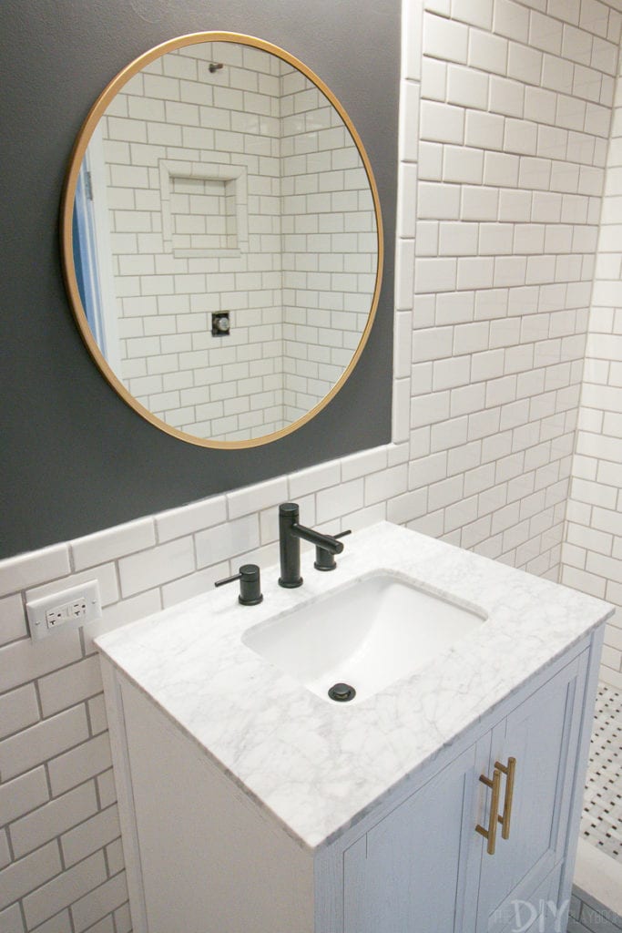 A round mirror looks good next to the straight lines of subway tile