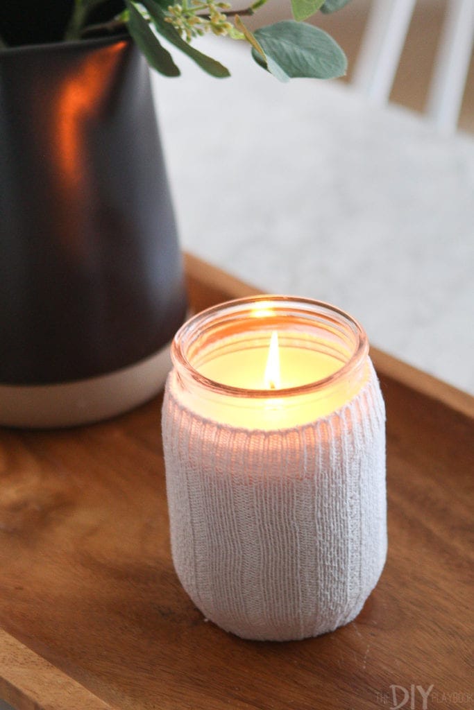 A lit candle with a sock candle holder
