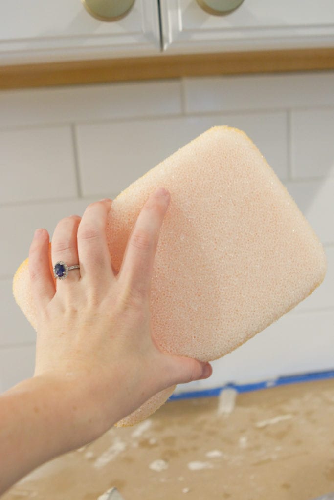 using a sponge to wipe off all extra grout