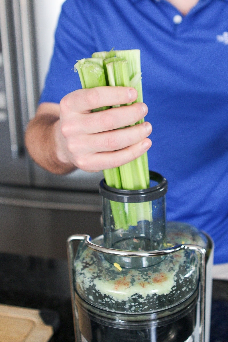 Adding celery stalks to the juicer