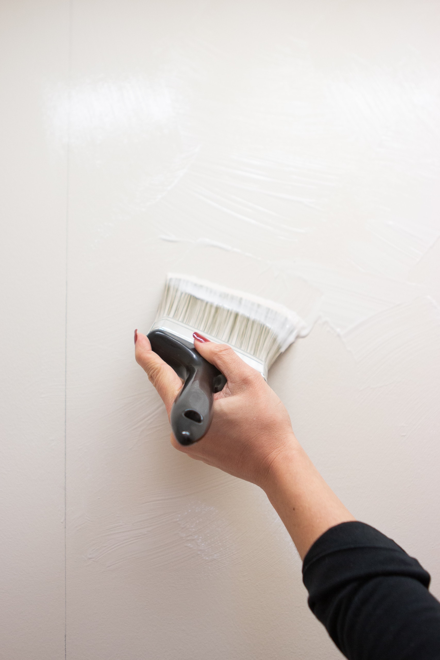 Applying wallpaper paste to the wall