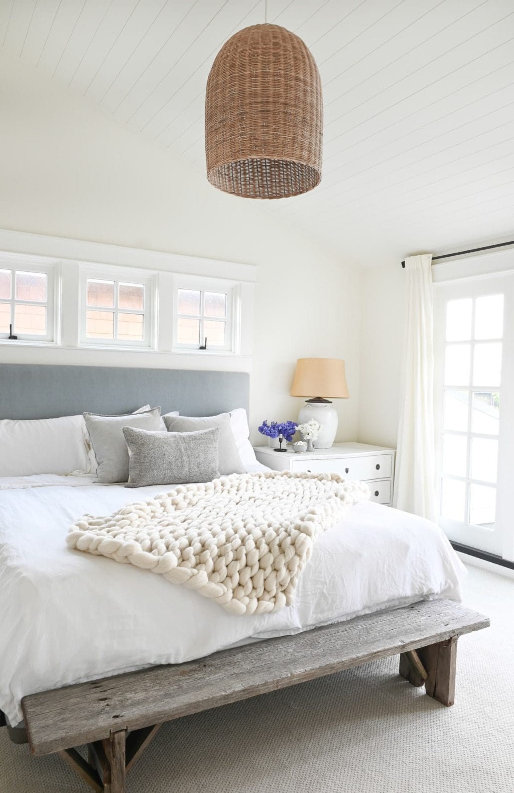 Bright bedroom with gray headboard and textured lantern