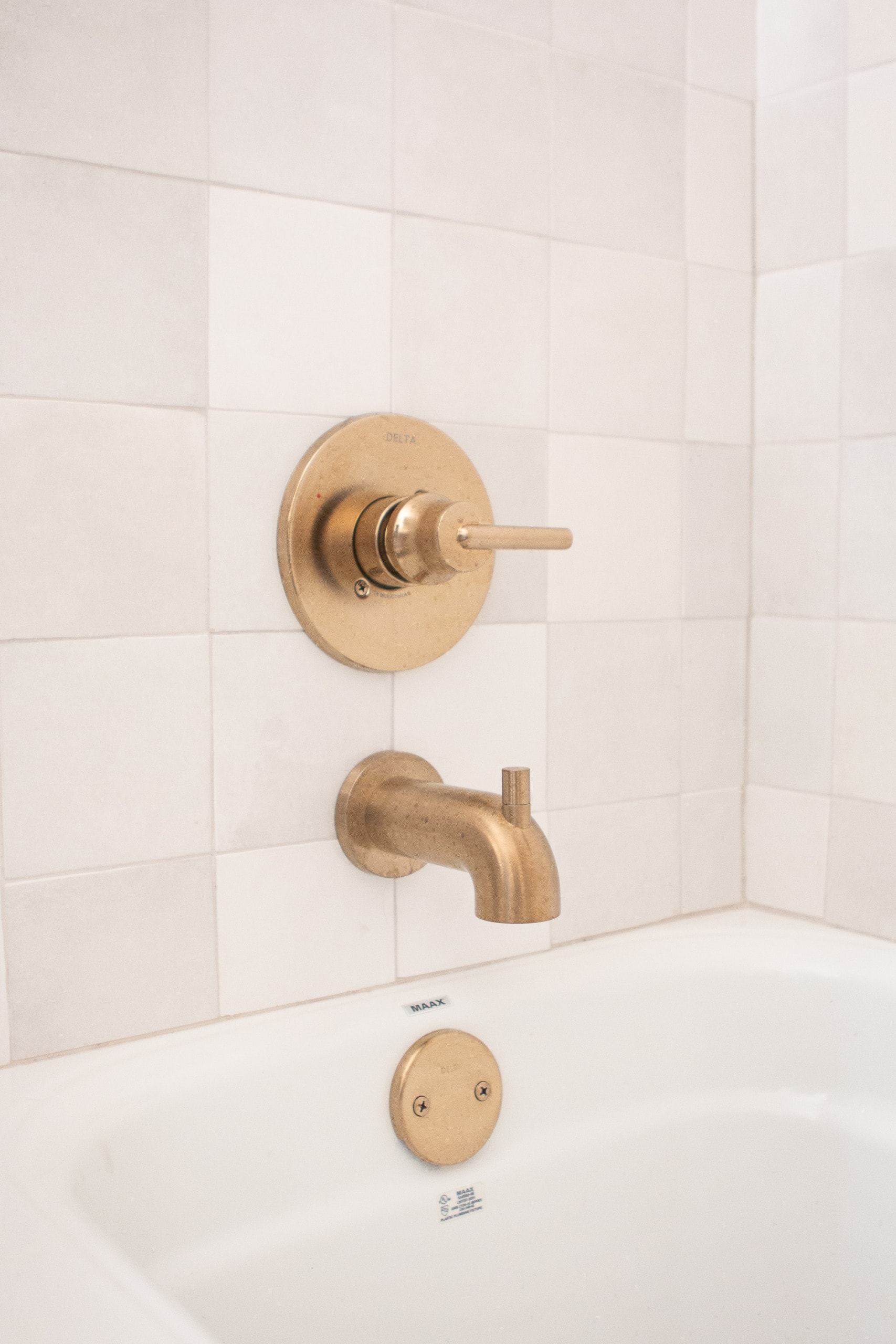 white tile and brass shower hardware