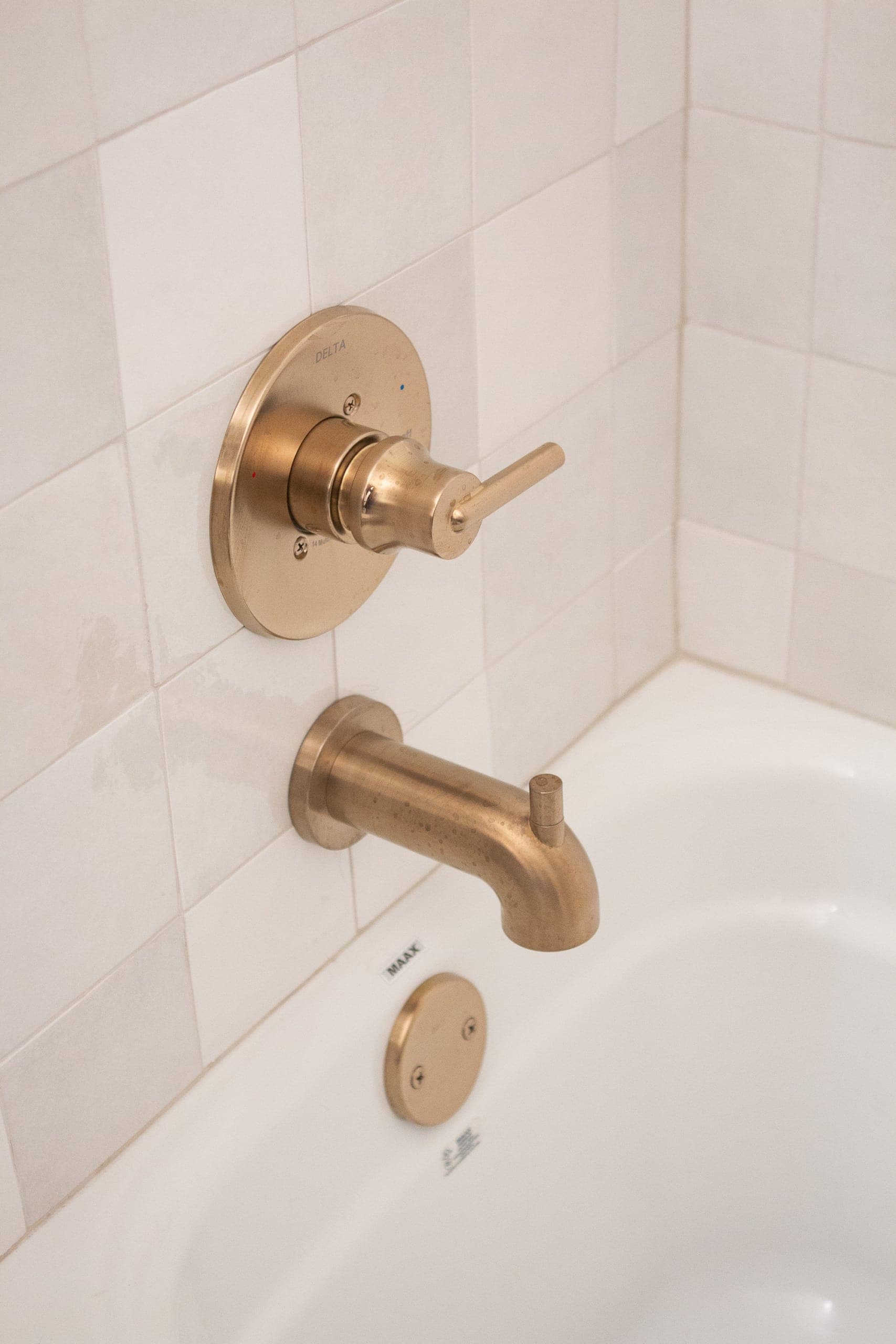 Brass shower hardware with white tile