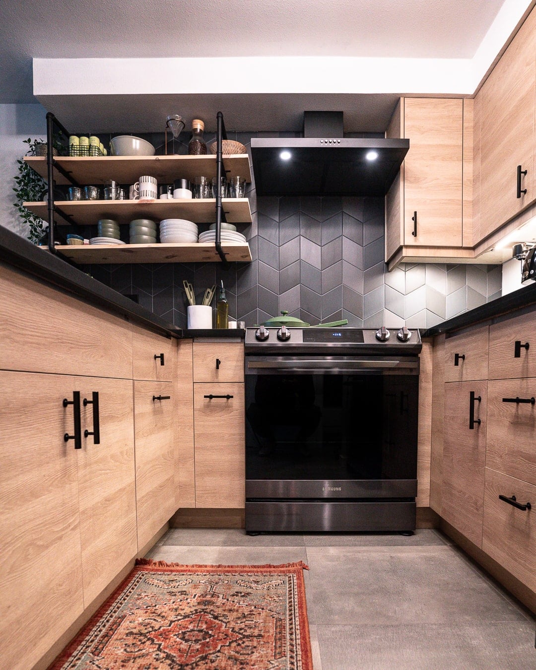 galley kitchen with moody backsplash and wood open shelves