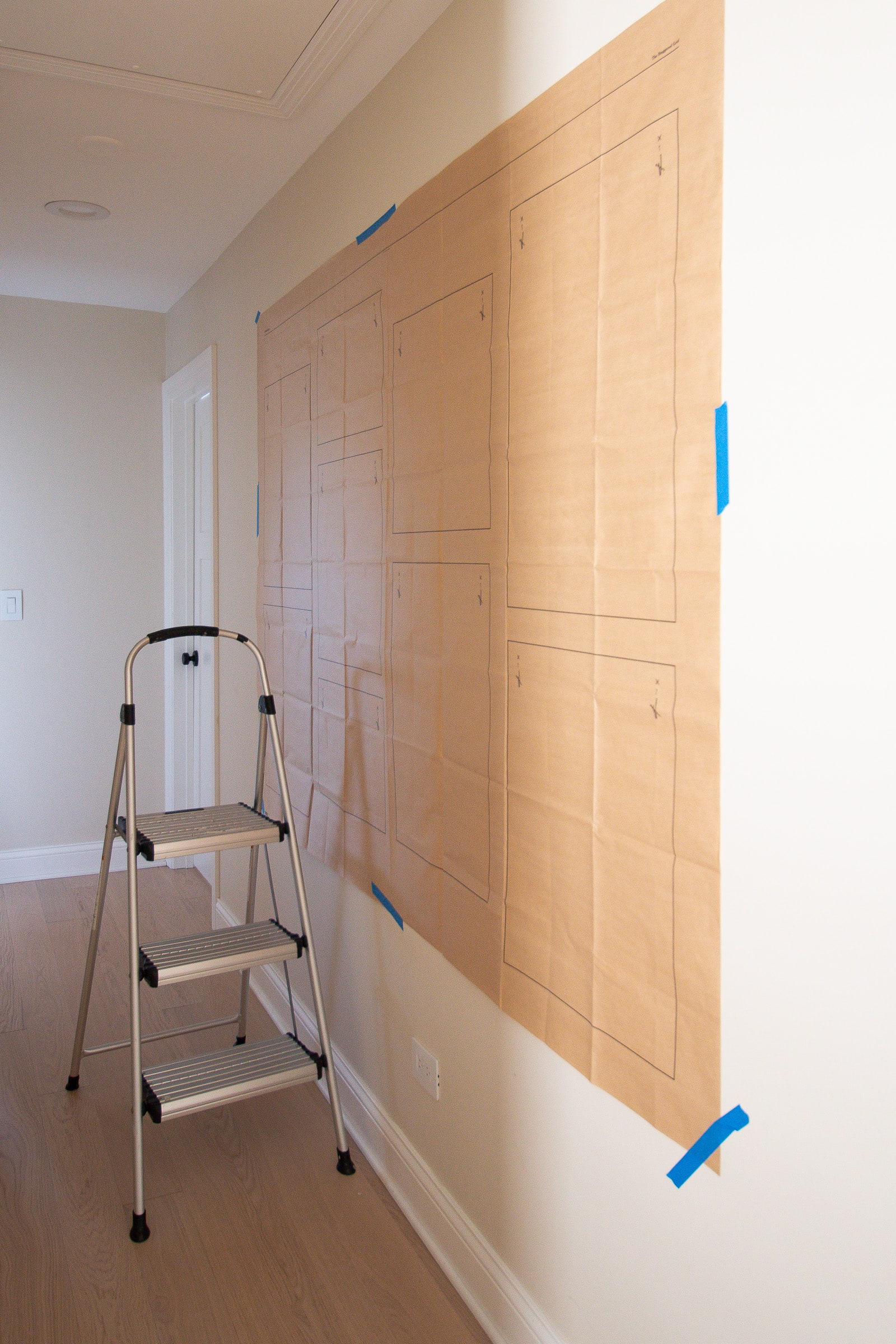 Using a hanging guide to hang a hallway gallery wall