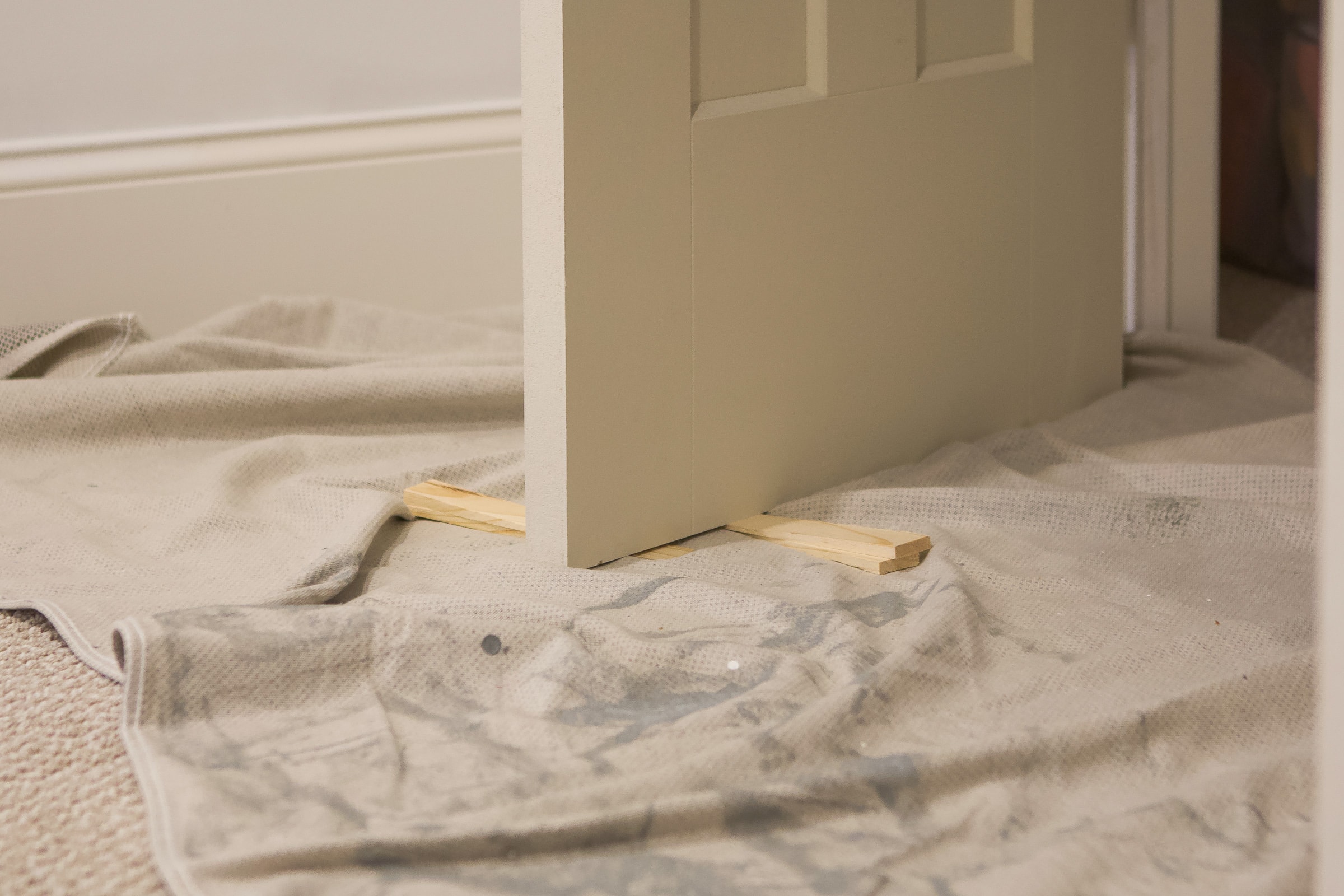 Use wood shims to keep your door in place while you paint