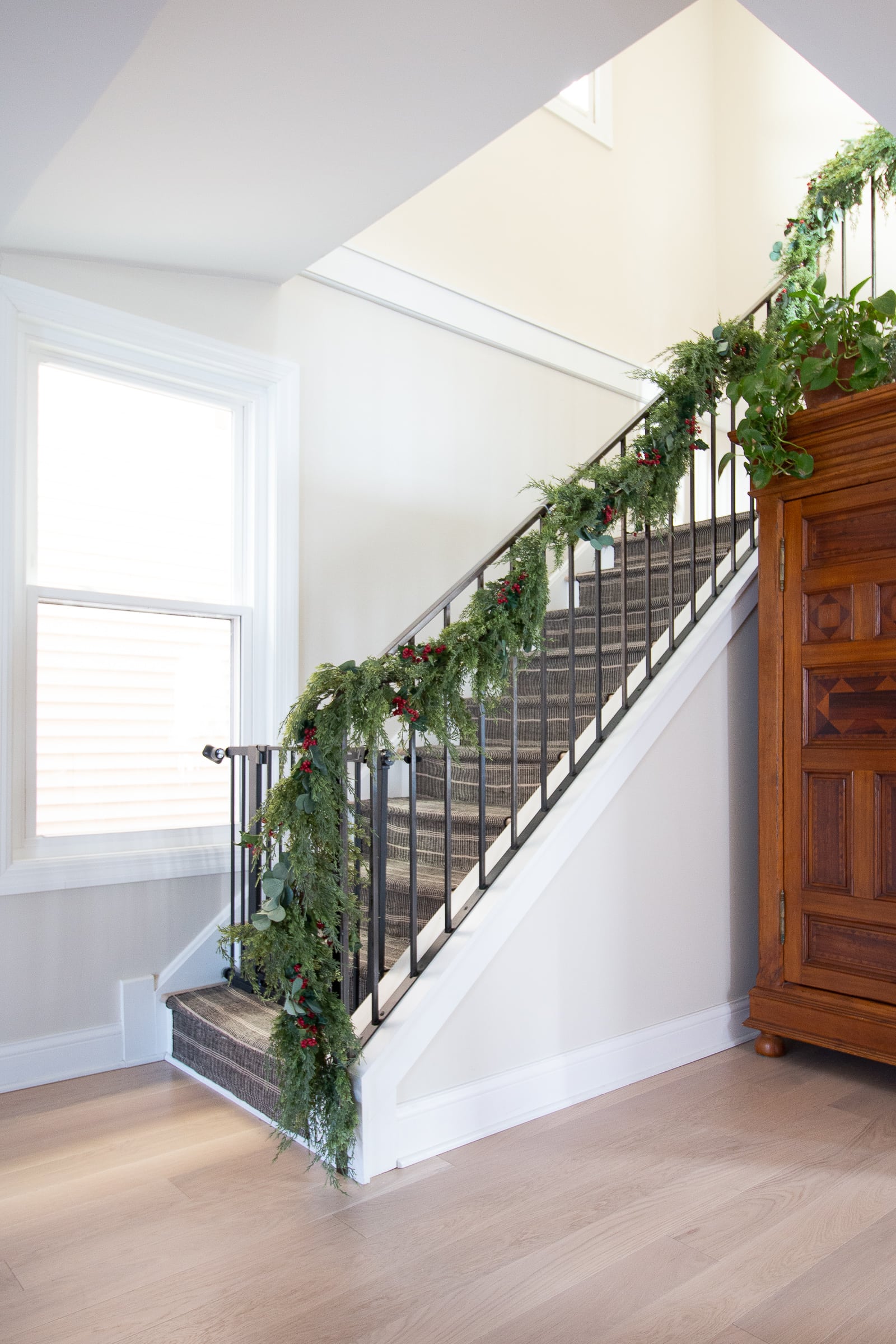 Adding garland to our holiday banister