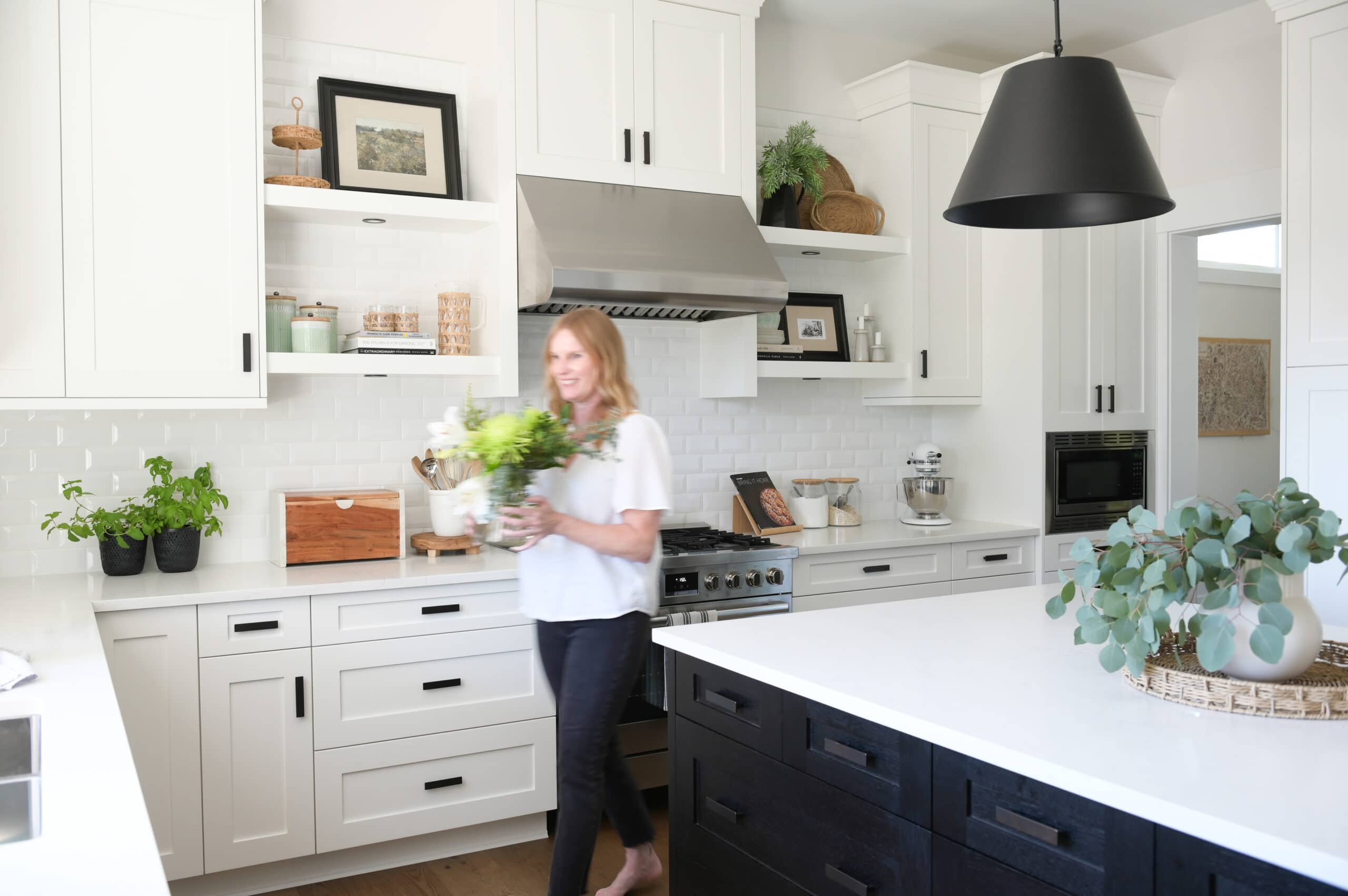 A black and white kitchen with large black pendants 