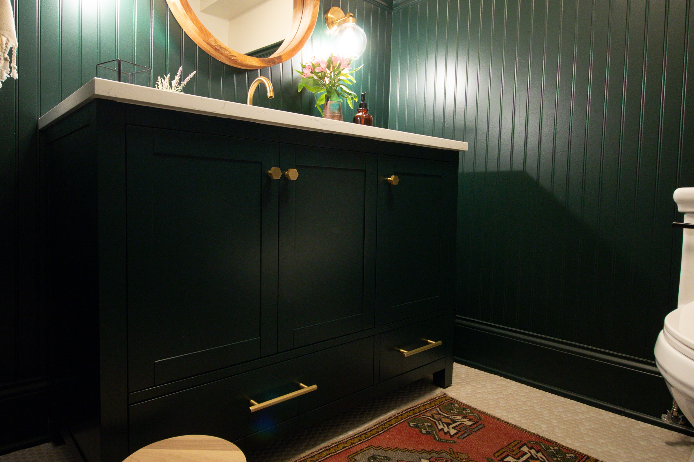 A dark green vanity in a bathroom