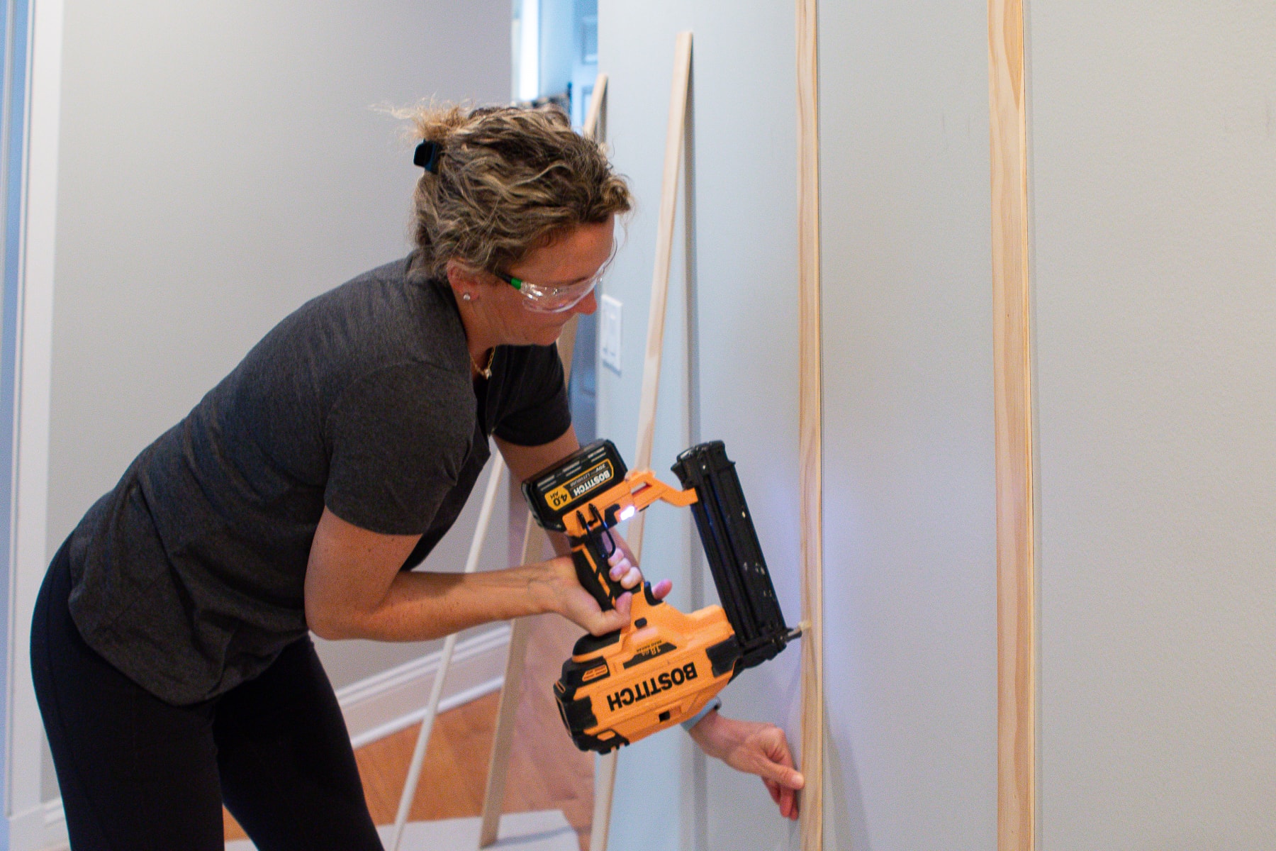 Liz working hard to attach the lattice to the board and batten wall DIY project 