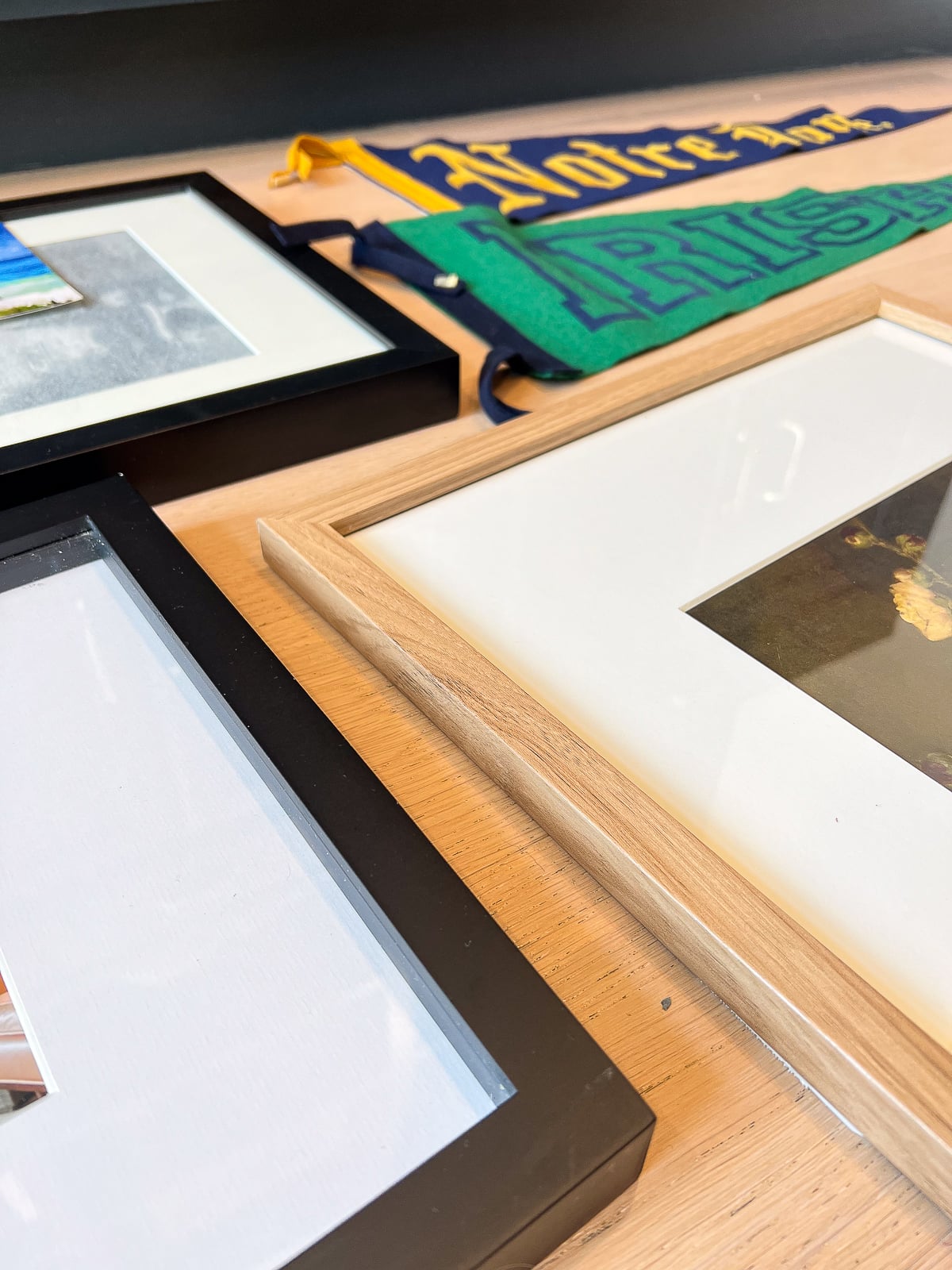 Use a mix of wood, black and gold for your picture frames