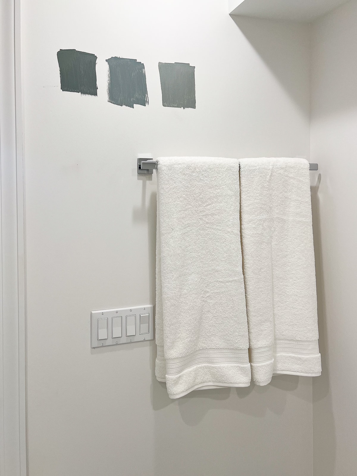 Peignez des couleurs sur le mur à côté d'une serviette blanche sur un porte-serviettes