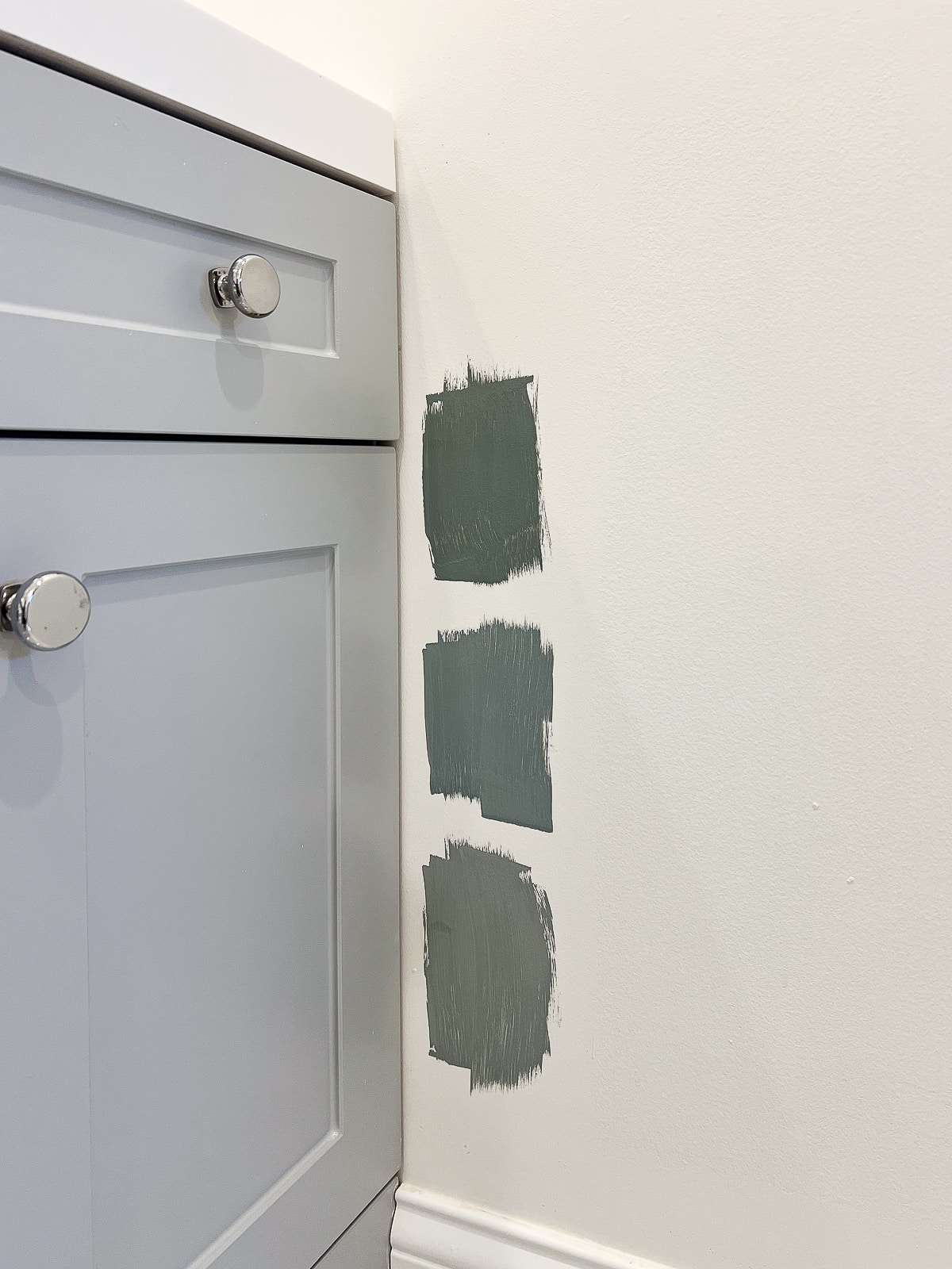 Peindre des échantillons de couleurs à côté de la vanité grise dans cet espace de salle de bain