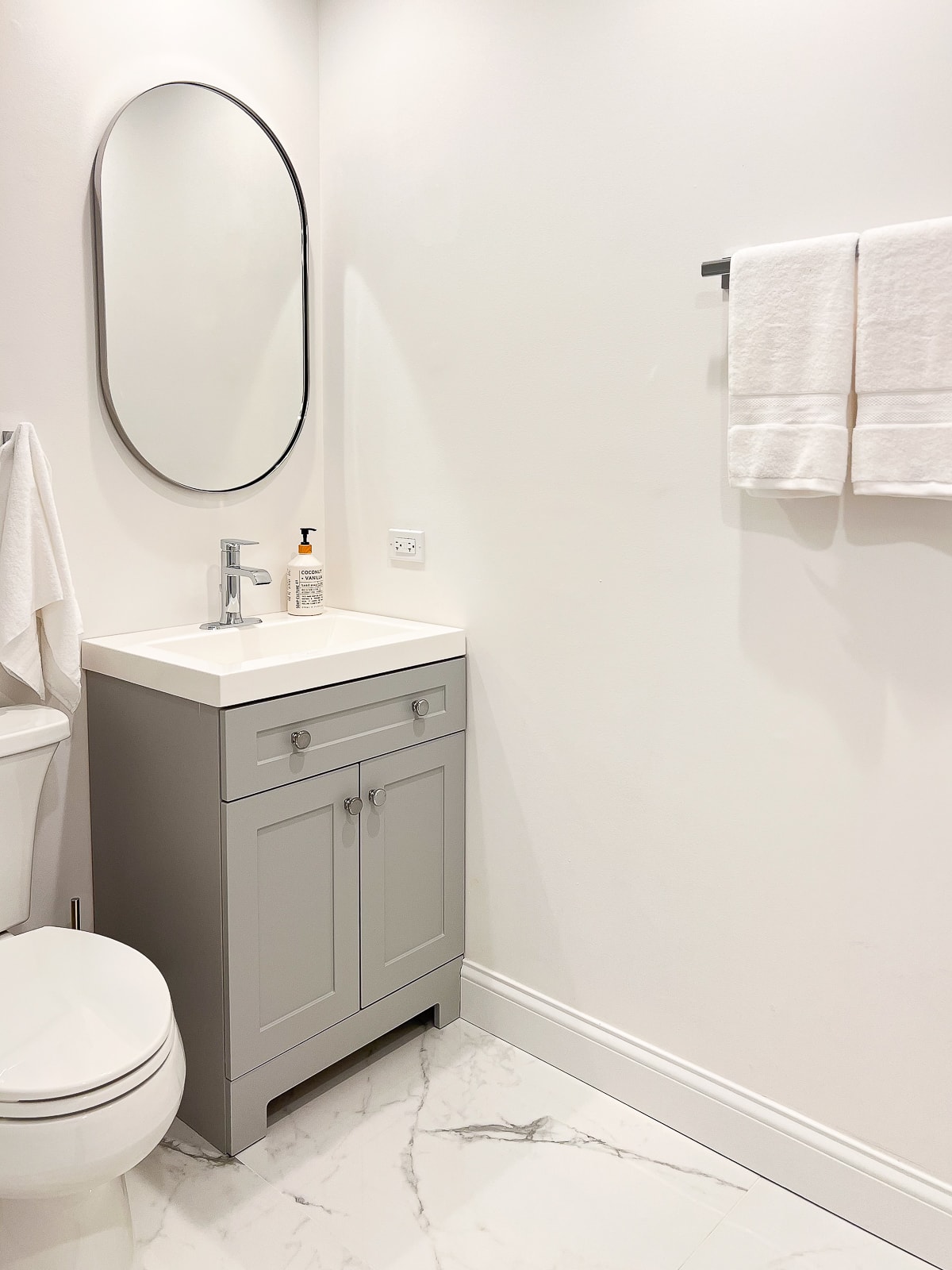 Une vasque grise et des murs blancs dans cette petite salle de bain sans fenêtre