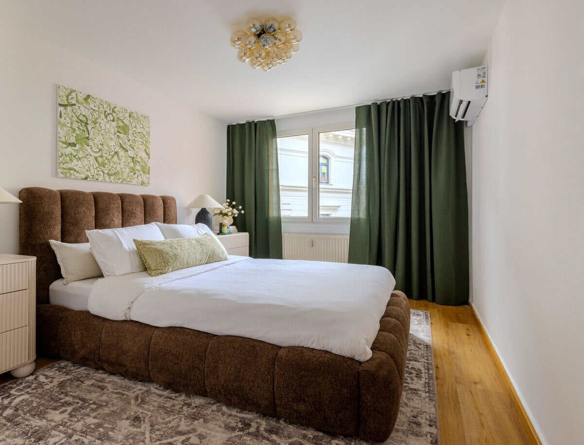 Brown platform bed and green curtains