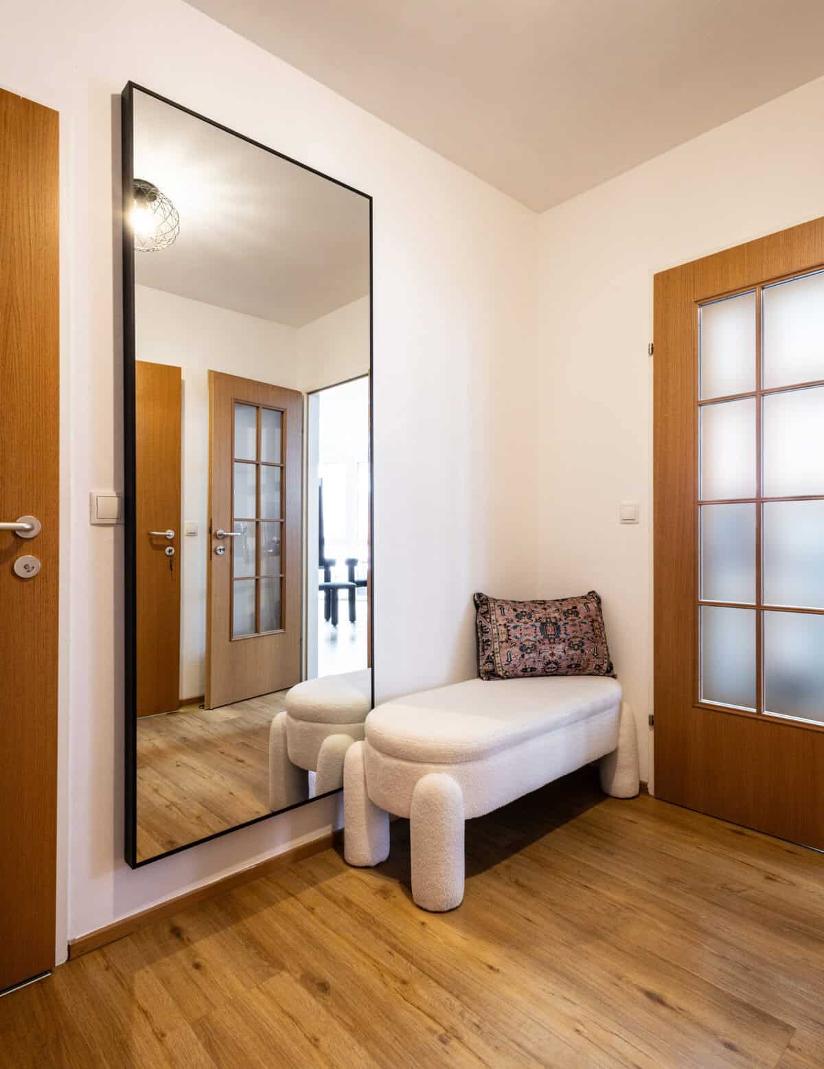 A large mirror and bench in an entryway