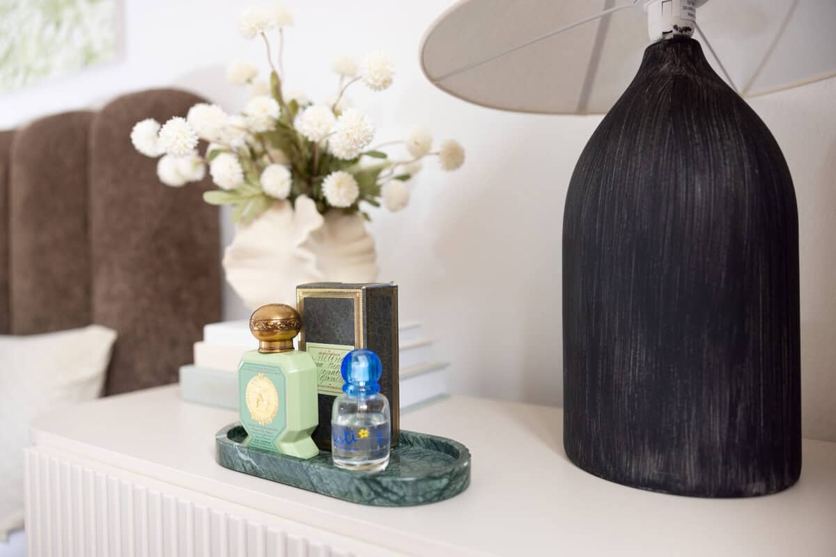A green tray on a nightstand to hold perfume